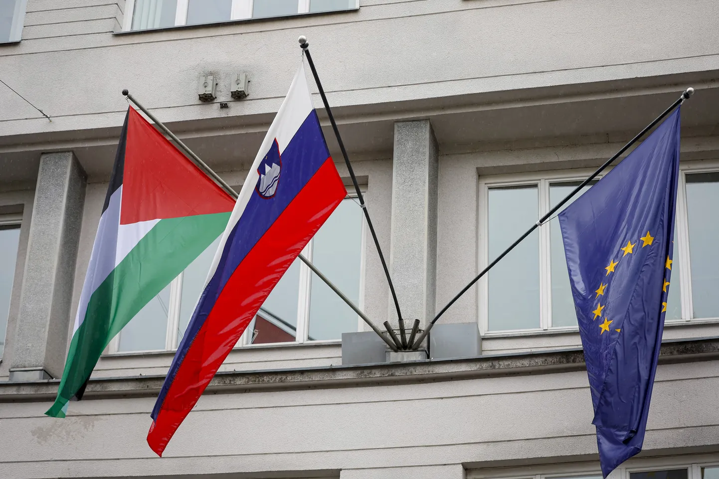 Palestiina lipp lehvimas Sloveenia ja Euroopa Liidu lipu kõrval Ljubljana valitsushoone seinal.
