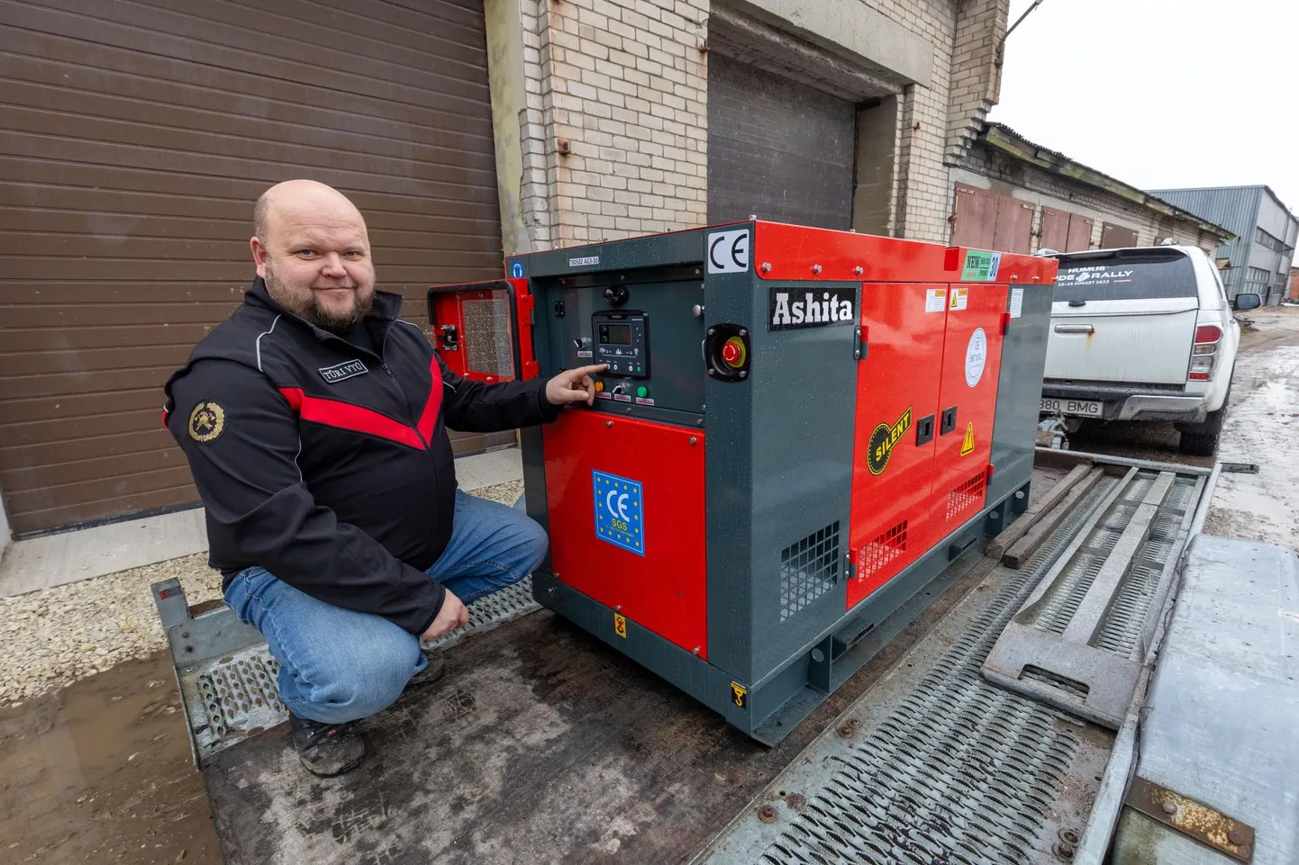 Illustreeriv foto. Vabatahtlik päästja Meelis Välimäe näitab uut elektrigeneraatorit, mida on võimalik auto järelkäruga soovitud kohta vedada.
