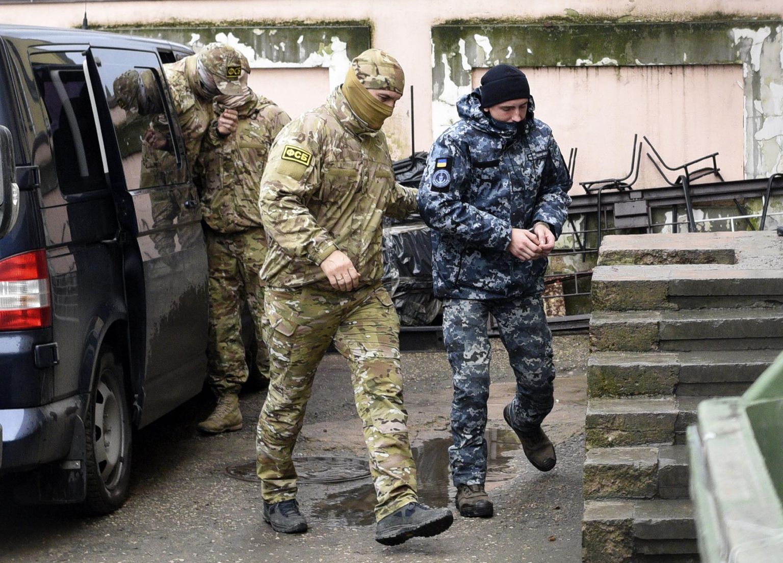 Venemaa Föderatsiooni Föderaalse Julgeolekuteenistuse (FSB) töötaja toimetamas venelaste kätte langenud Ukraina mereväelast Simferoopoli kohtusse.