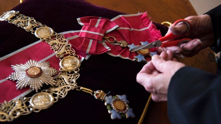 Награды и знаки отличия герцога пришиваются к подушкам, выложенным в алтаре.