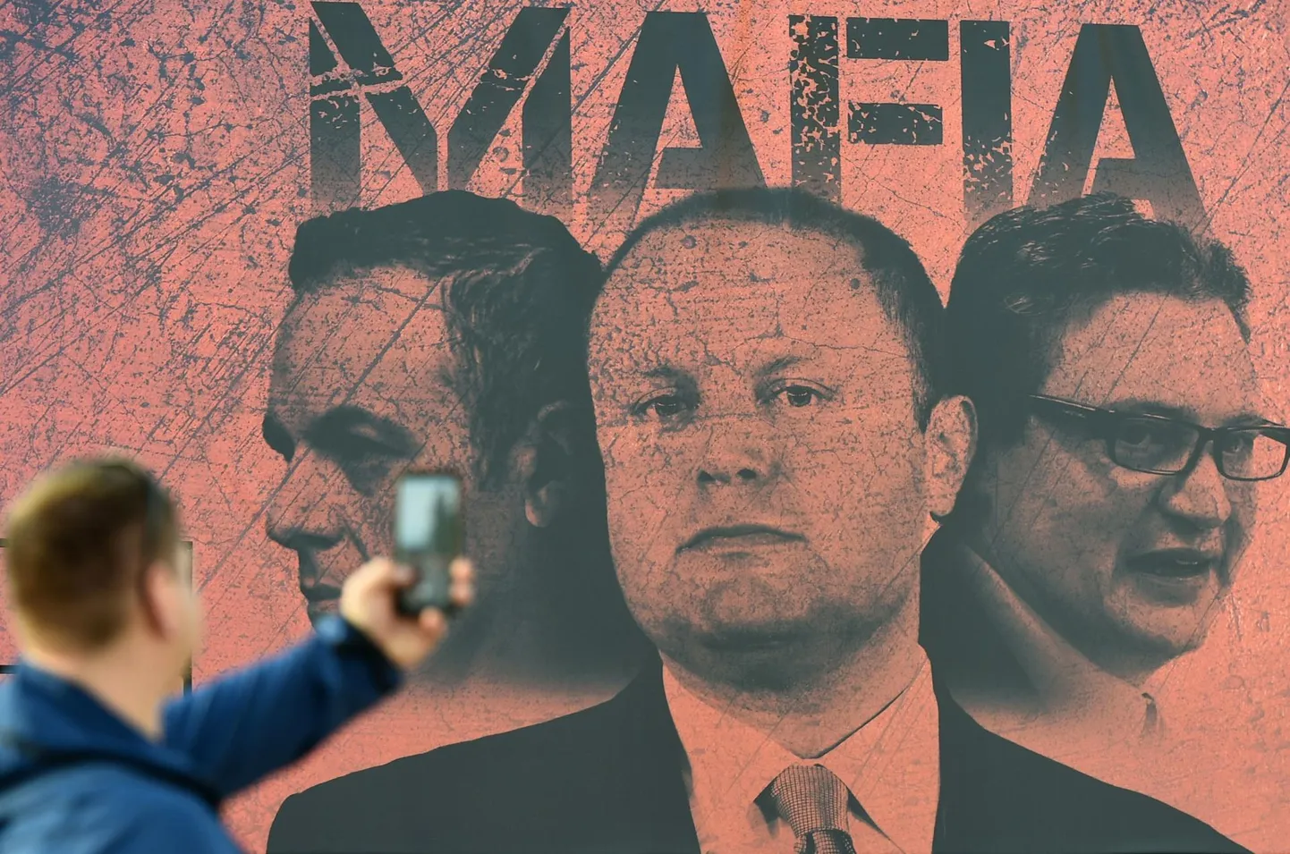 Plakat peaministri büroo lähedal Vallettas, millel tembeldatakse peaminister Joseph Muscat (keskel), endine peaministri kabinetiülem Keith Schembri (vasakul) ja endine turismiminister Konrad Mizzi maffiaks.
