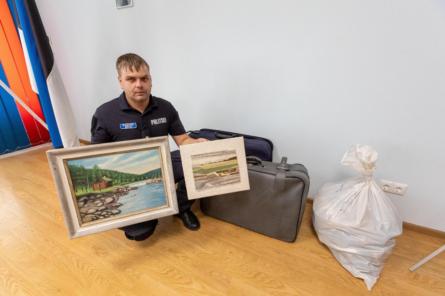 Paide politseijaoskonna korrakaitseametnik Raimond Innos näitab Pärnu–Rakvere maanteelt leitud suurte reisikohvrite ja kilekoti sisu. Peale jalanõude avastasid politseinikud neist ka mitu maali.