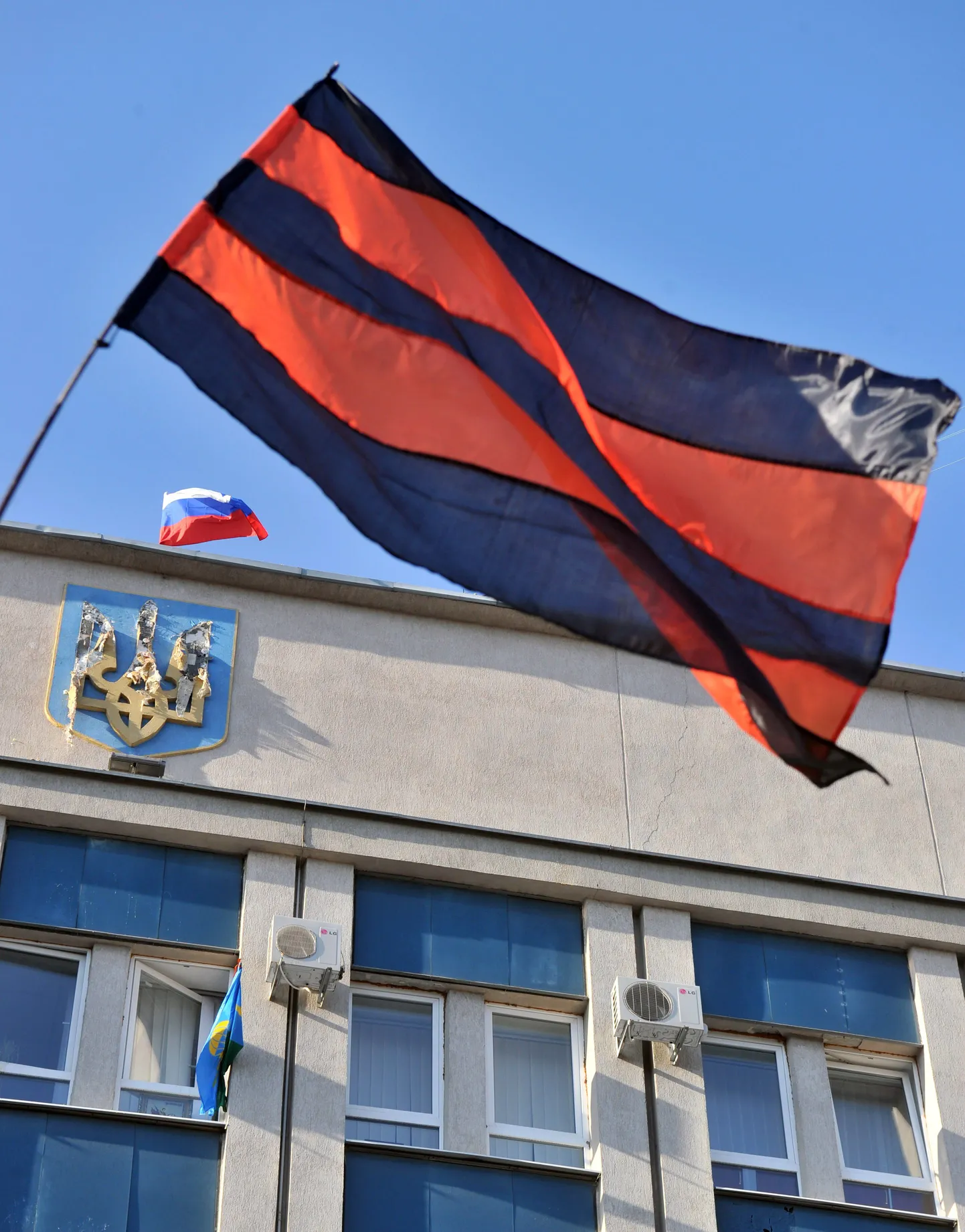 Venemeelse opositsiooni ja Venemaa lipud Luganskis julgeoleketeenistuse hoone juures ja hoonel. Akmast on välja torgatud Ukraina lipp.