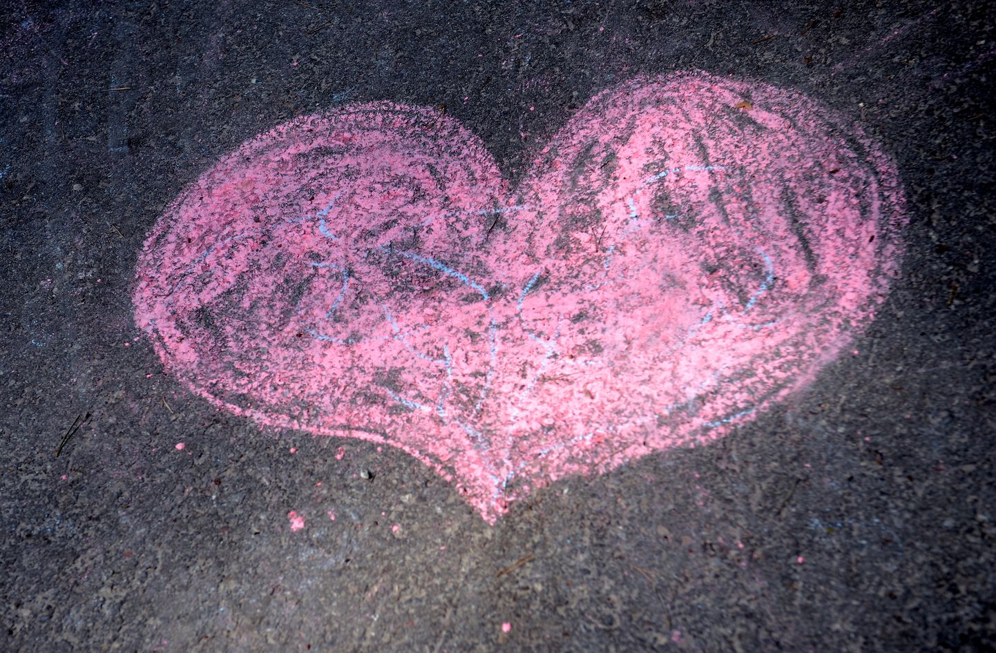 Ar krītiņiem uzzīmēta sirds uz asfalta.
