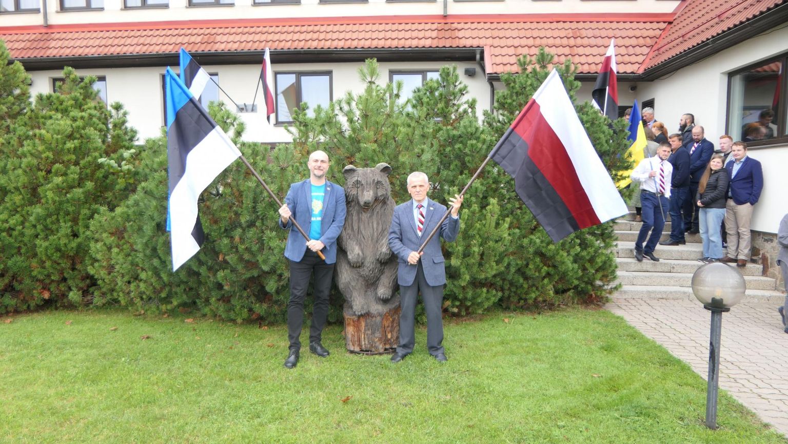Oliver Loode ja Sõress Boläeń eesti ja ersa rahvuslippudega Otepääl, taamal ersa kongressi delegaadid FOTO: Oliver Loode