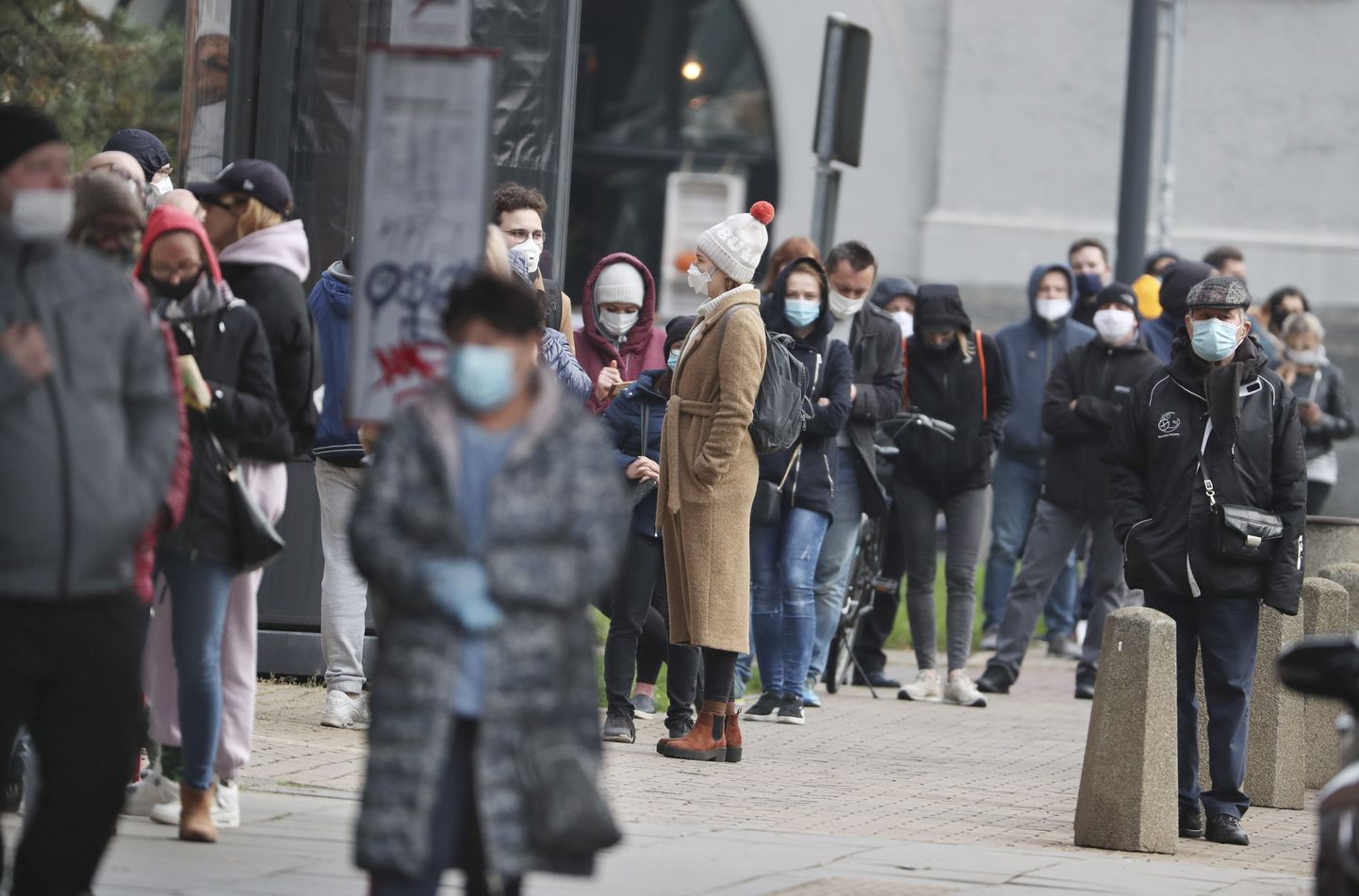 Жители Варшавы стоят в очереди, чтобы сделать тест на коронавирус.