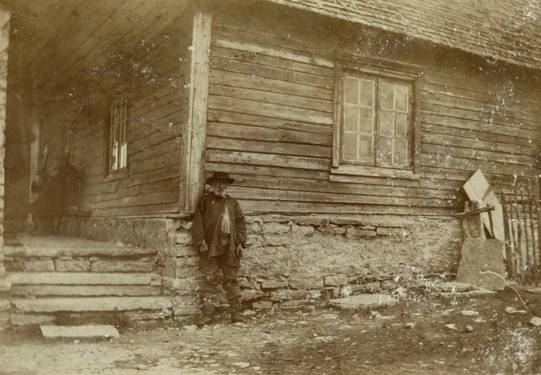 Pildil vana mees seismas Harku kõrtsi ees, umbes 1900.