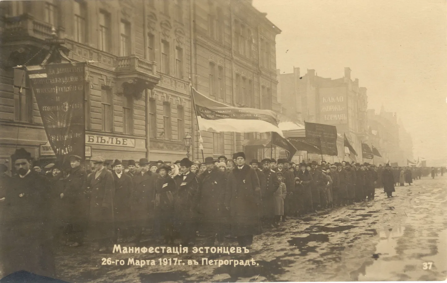 Umbes 40 000 eestlase manifestatsioon Eesti autonoomia toetuseks kogunes Petrogradis vana kalendri järgi 26. märtsil 1917 Ohvitseride (praegusele Dekabristide) tänavale Jaani kiriku kõrval. Esiplaanil on uhke kübaraga daam Adele Hirsch ja tema kõrval abikaasa Johannes Hirsch, mõlemal mantlirevääril sinimustvalge lindi tükike.