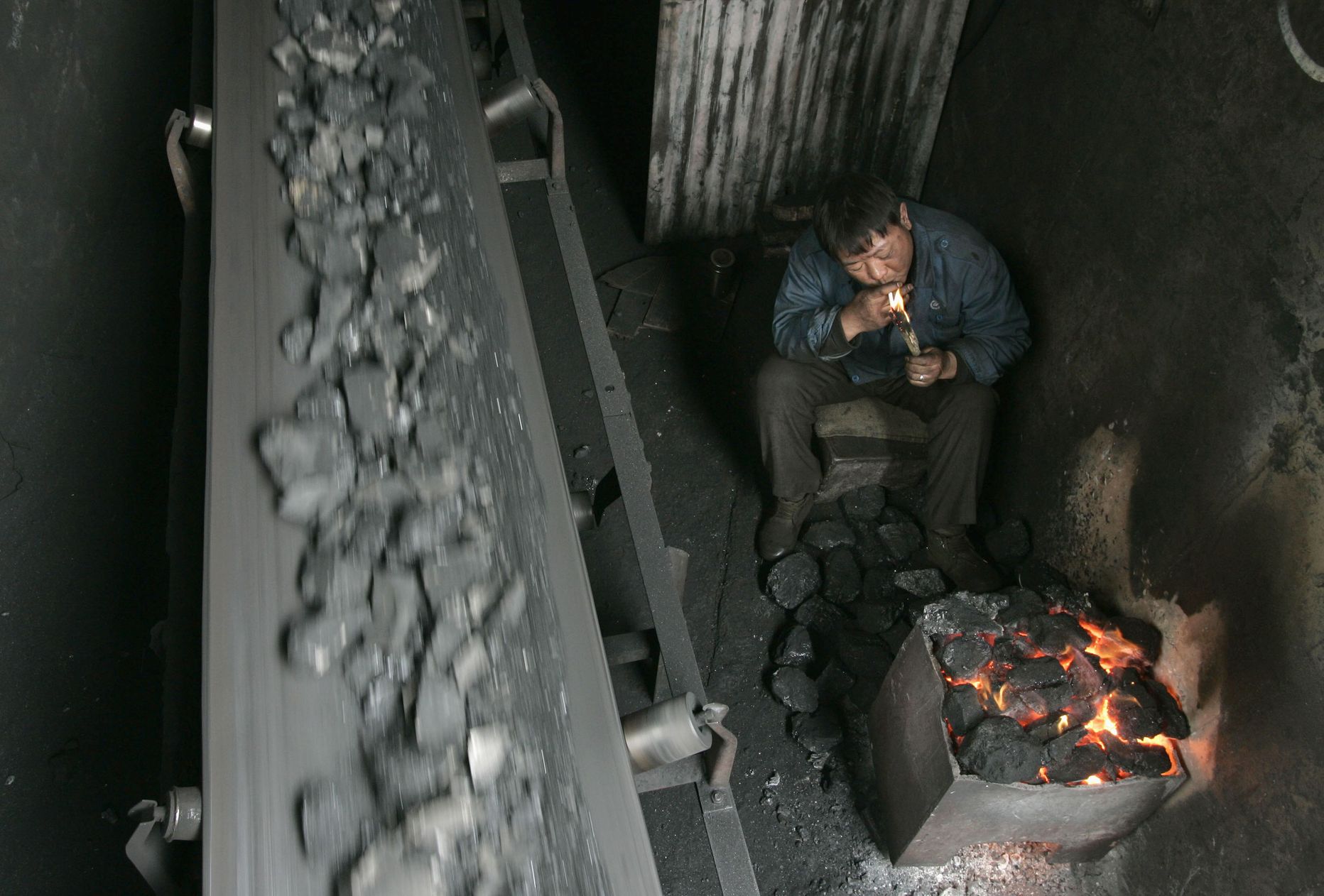 Hiina tööline süütamas sigaretti ühes söekaevanduse töökojas.