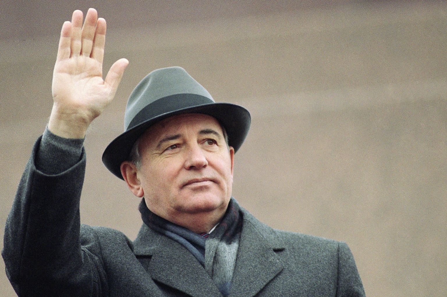 Президент СССР Михаил Горбачев машет рукой с трибуны на Красной площади в Москве на праздновании Годовщины Великой Октябрьской социалистической революции. 7 ноября 1989 года.