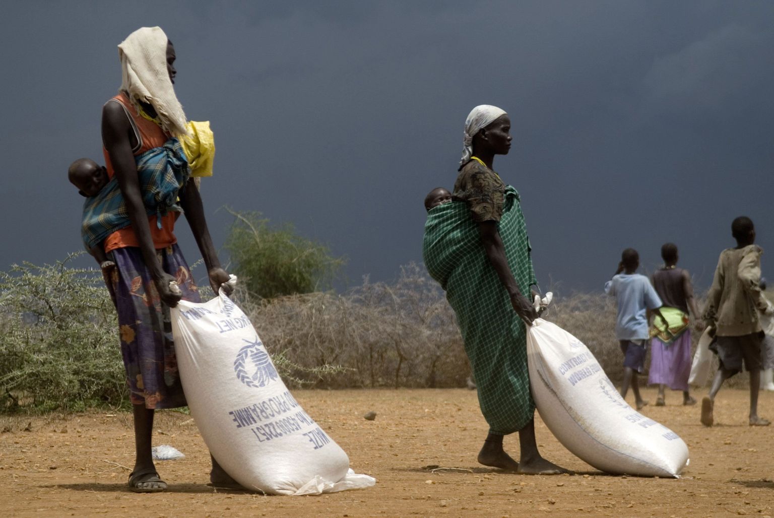 Uganda naised toiduabina saadetud vilja vedamas