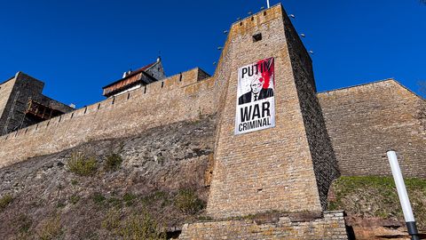Галерея ⟩ На стене Нарвского замка вывесили плакат с надписью «Путин – военный преступник»
