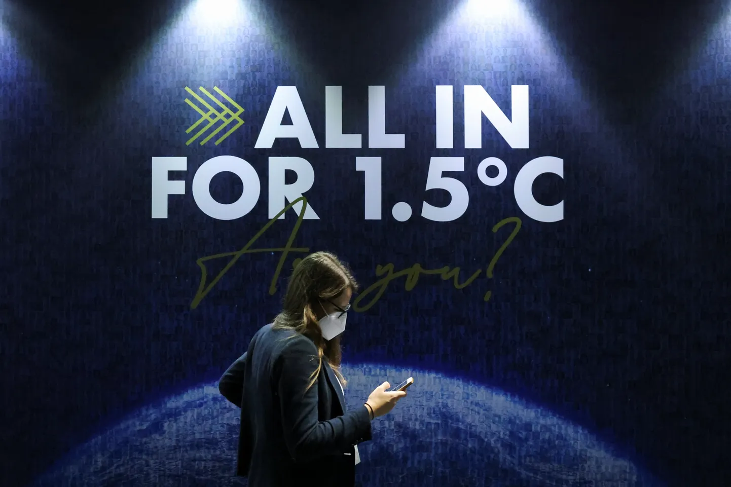 A delegate walks past a sign during the UN Climate Change Conference (COP26) in Glasgow, Scotland, Britain, November 11, 2021. REUTERS/Yves Herman