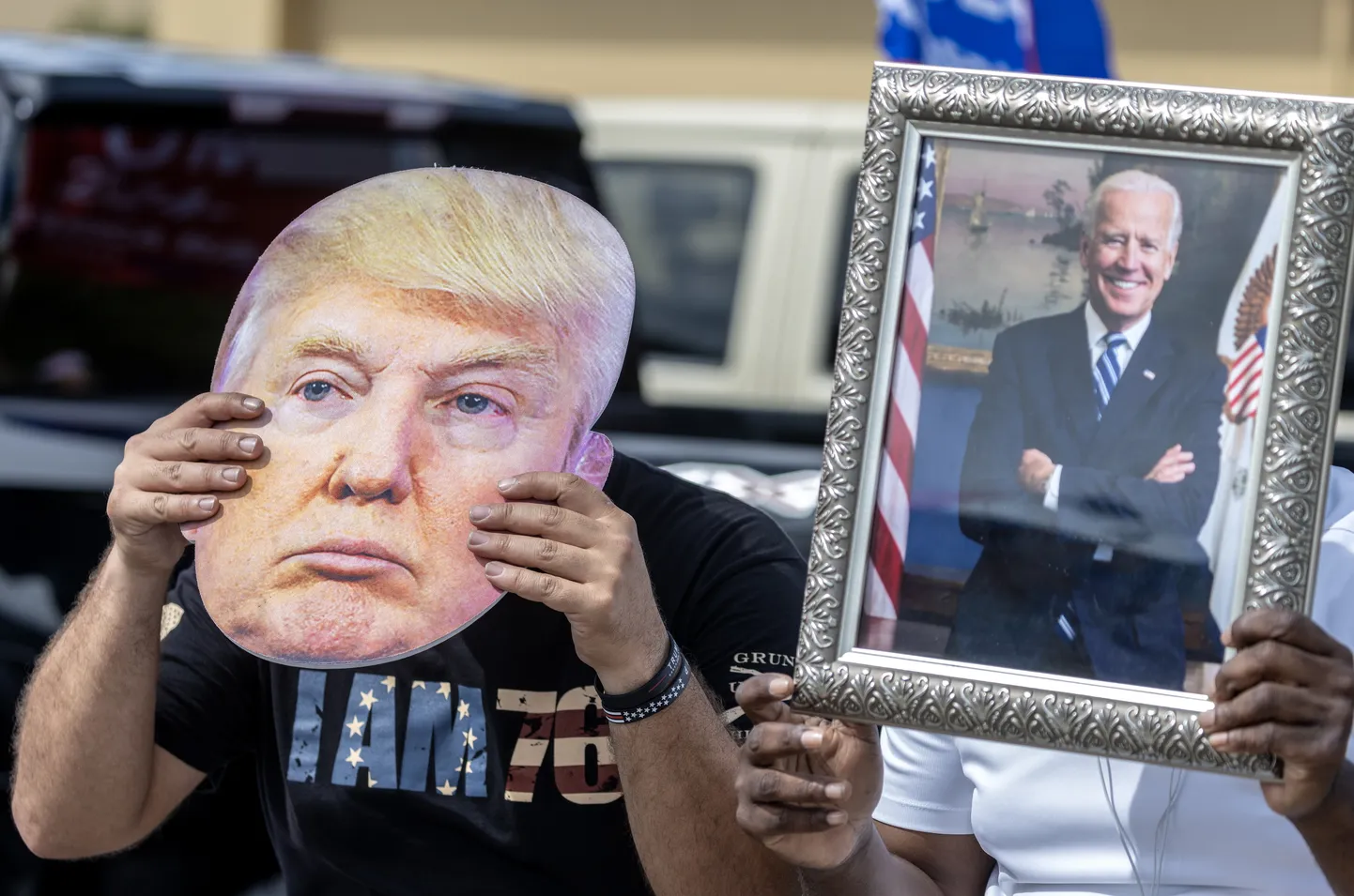 Человек с маской Дональда Трампа и портрет Джо Байдена