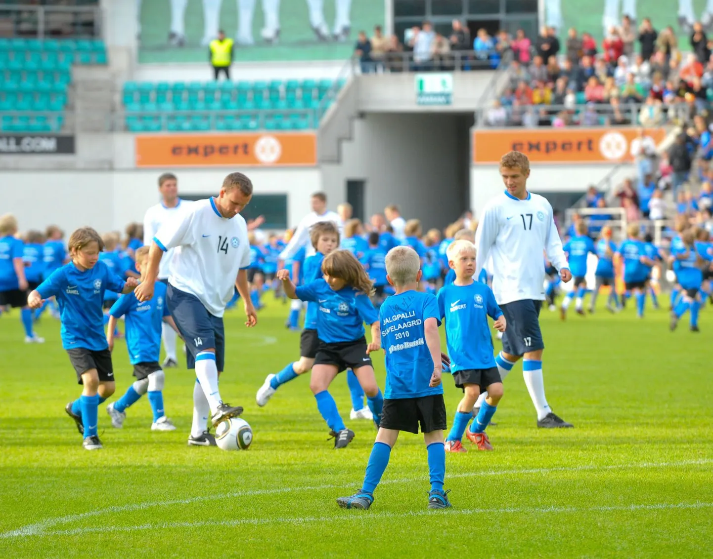 Eesti jalgpallikoondise poolkaitsja Konstantin Vassiljev (palliga) Lilleküla staadionil koos kaaslastega noortele huvilistele oma oskusi näitamas ning neile jalgpallipisikut süstimas.