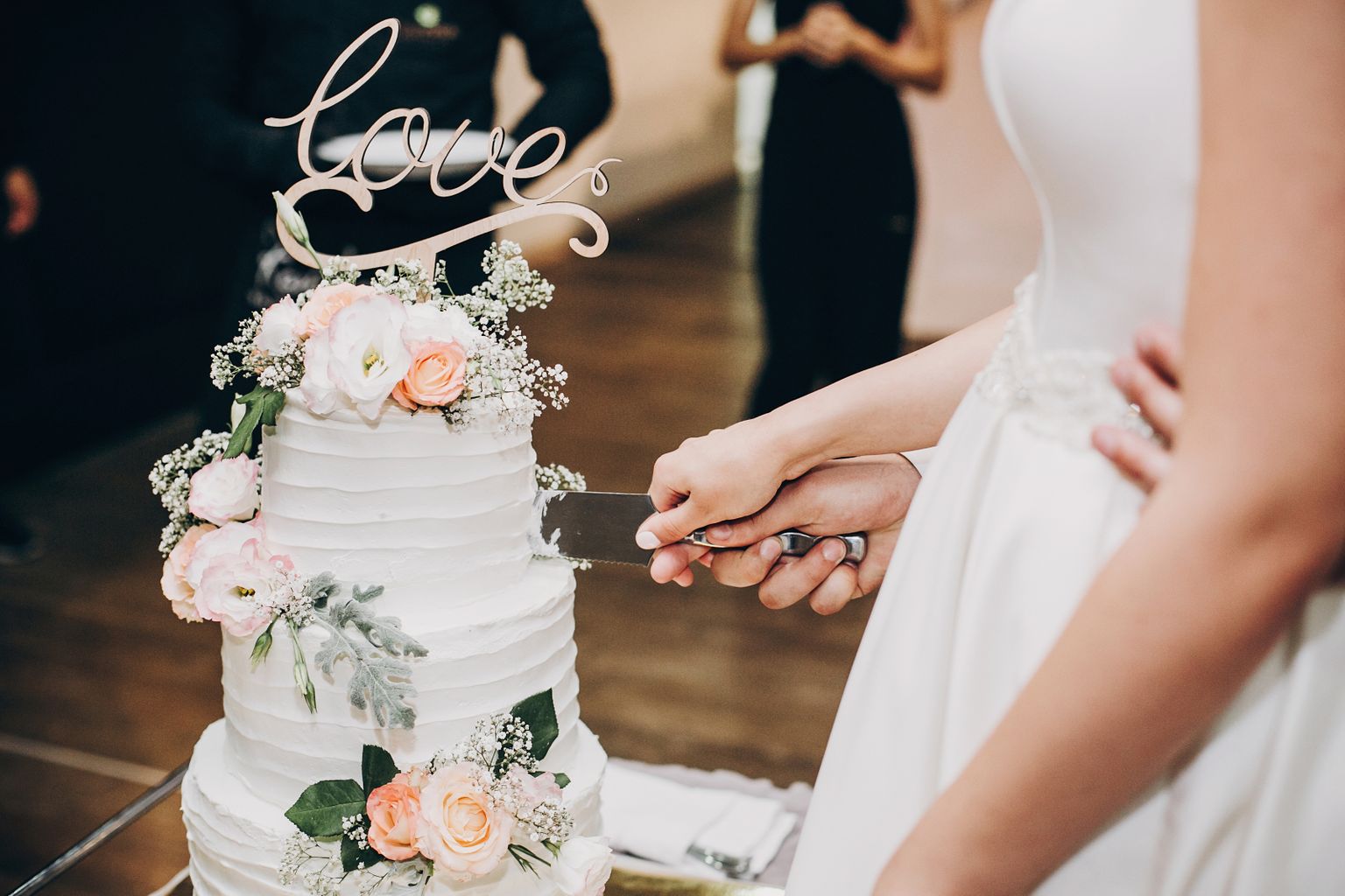 Невеста и жених режут свадебный торт. Иллюстративное фото