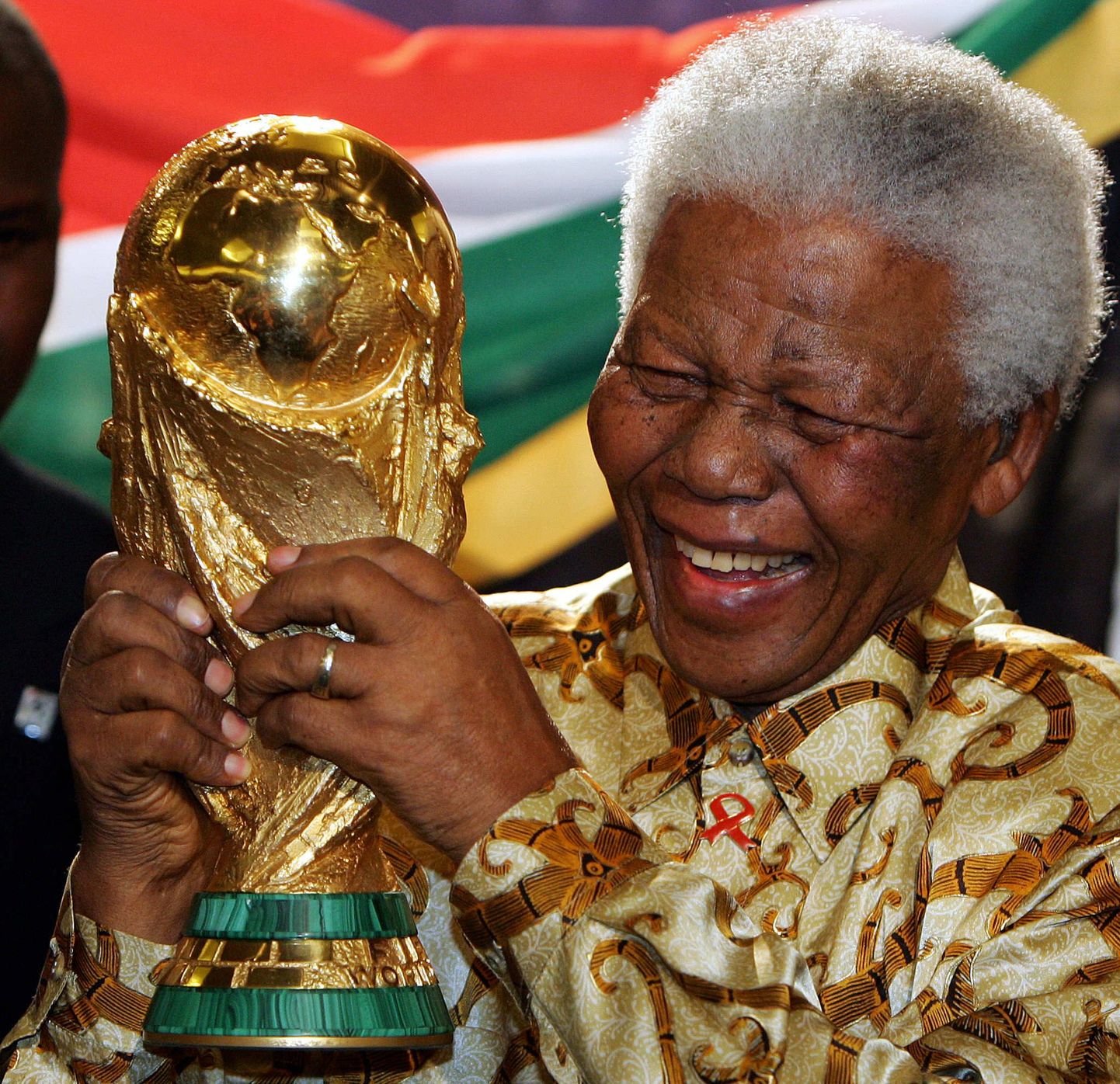 Nelson Mandela 2004. jalgpalli MMi trofeega. Äsja oli Lõuna-Aafrika Vabariik saanud 2010. aasta MMi korraldusüõiguse.