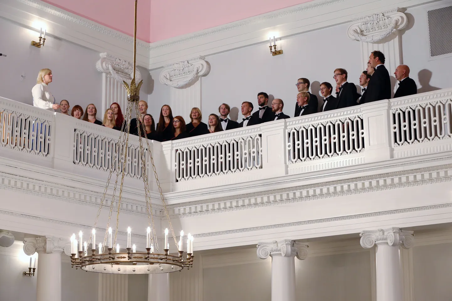 Tartu ülikooli kammerkoor on aulas esinenud mitmel tasandil, nagu näiteks rõdul. Dirigeerib Triin Koch.
