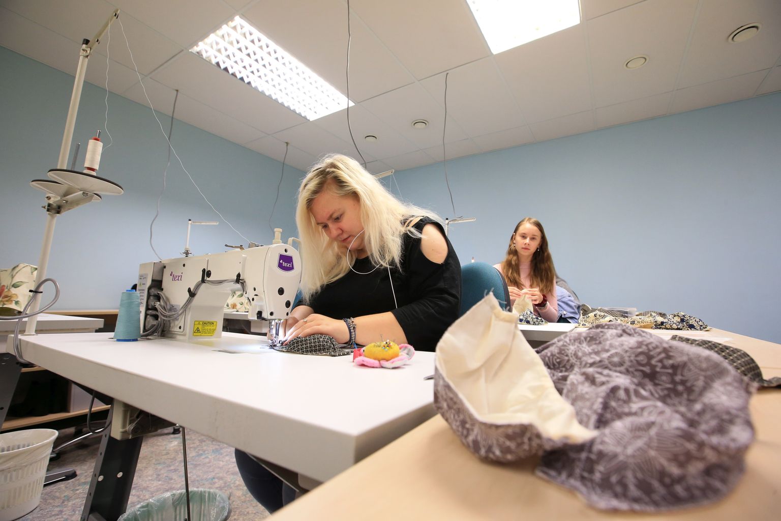 Tartu kutsehariduskeskuse tekstiili osakonna õpilased. Pildil õmbleb iluteeninduse ja tekstiili osakonna 3. kursuse õpilane Kati-Linda Kattel kaitsemaski.