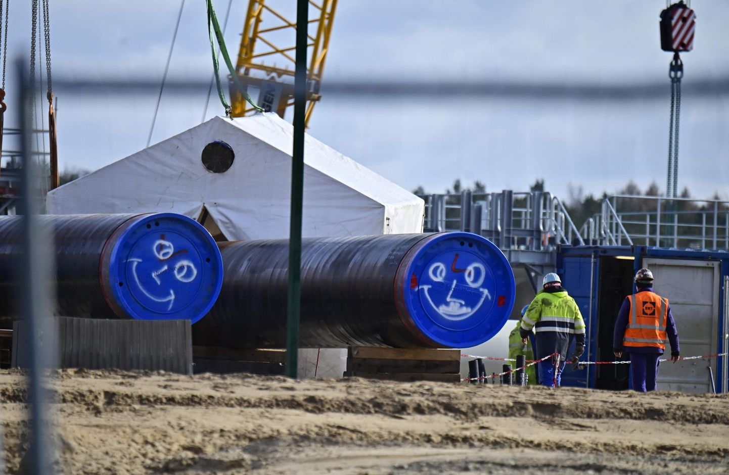 Töömehed toimetavad Kirde-Saksamaal Lubminis, kus gaasitorujuhe Nord Stream 2 peaks jõudma Läänemerest maismaale. Kuigi ehitusplatsil oma järge ootavatele torudele on kritseldatud peale naerunäod, võib Taani ettepanek muuta trassi teekonda jätta ehituse pikaks ajaks seisma.