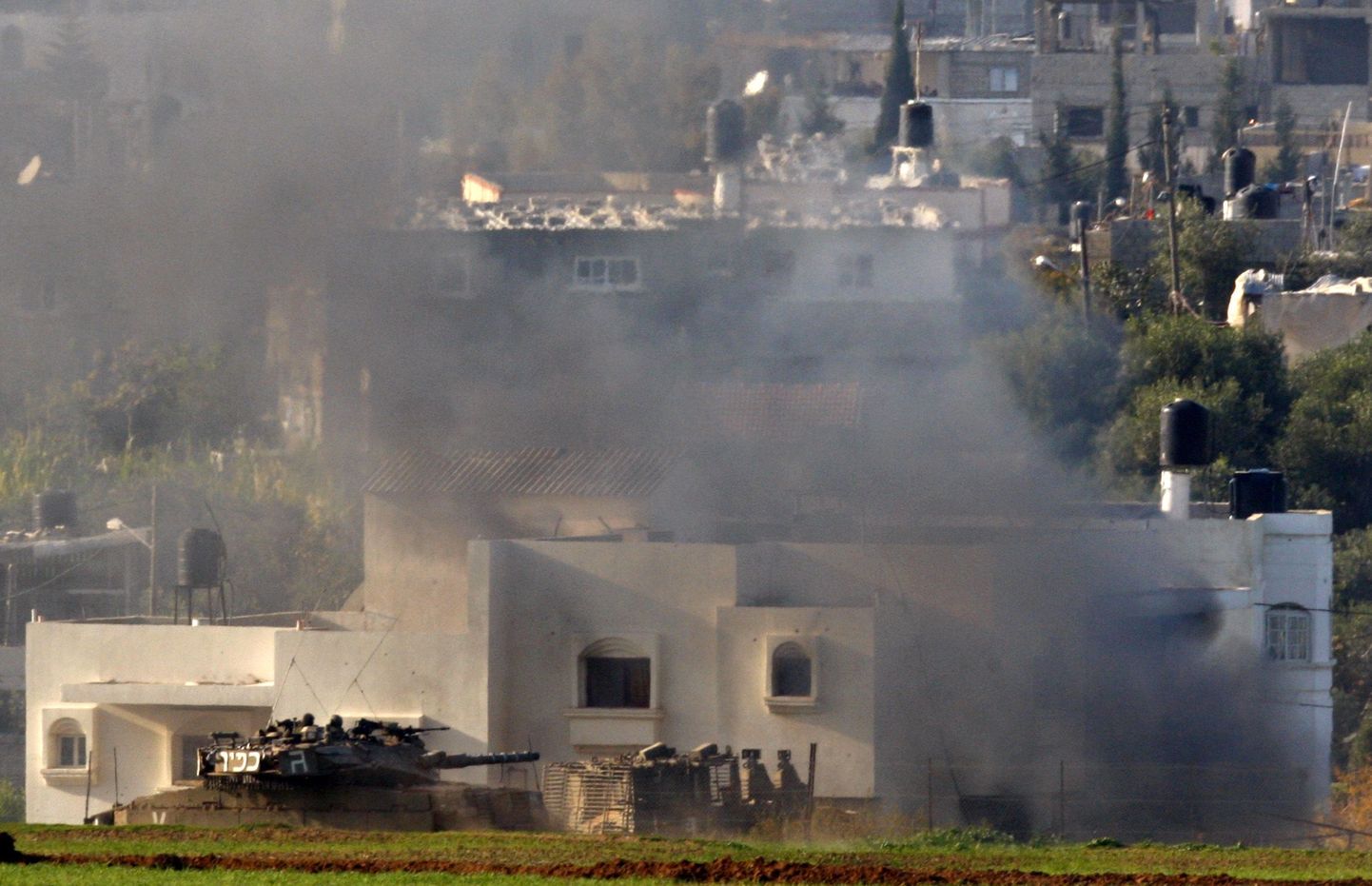 Iisraeli tank põleva maja ees Gaza tsooni põhjaosas.