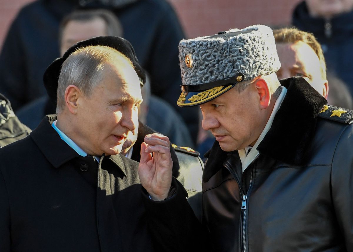 Путин беседует с министром обороны РФ Сергеем Шойгу во время возложения венка к могиле неизвестного солдата у Кремлевской стены, 23 февраля 2018 года.