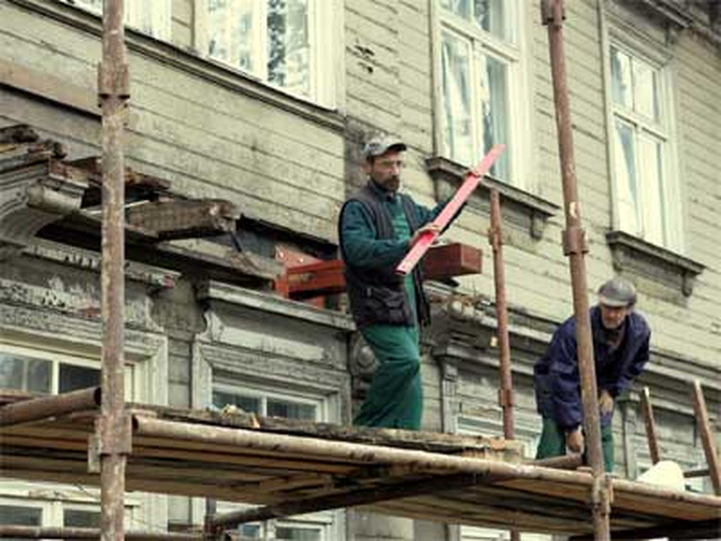 Strādnieki atjauno koka ēkas fasādi Rīgā, Kalnciema un Melnsila ielas krustojuma apkārtnē. Ilustratīvs attēls