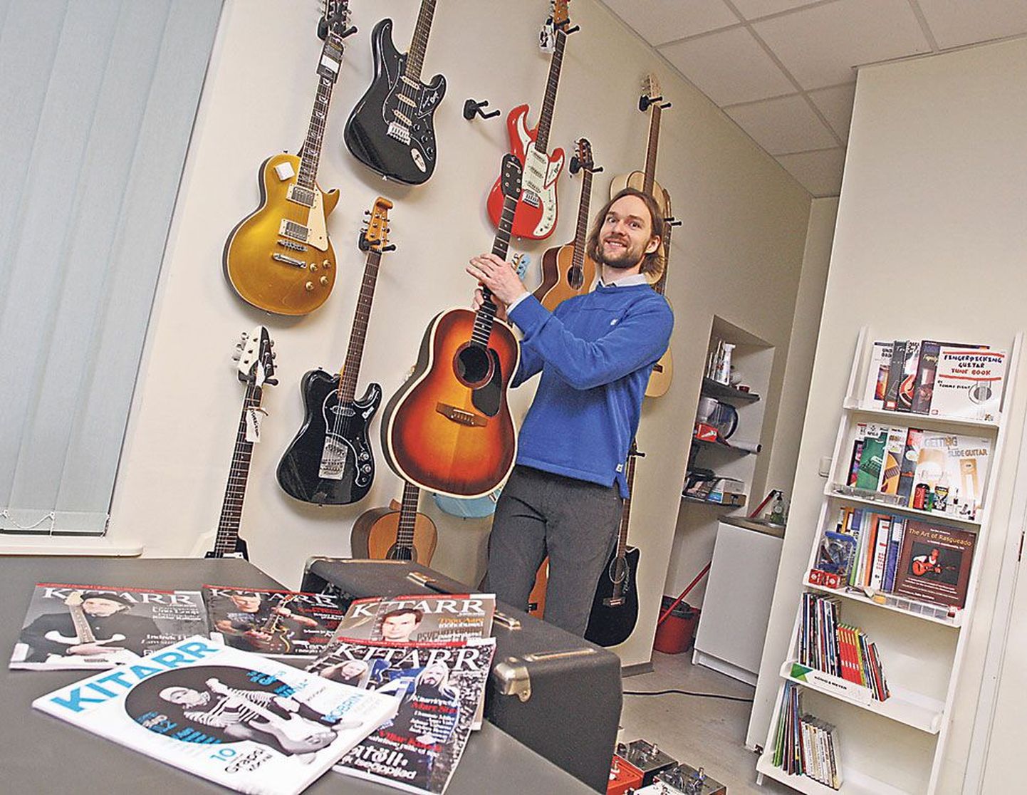 Ajakirja Kitarr peatoimetaja Kristo Käo võtab Tartus Küütri 14 hoones kitarrikooli ja ühtlasi toimetuse seinalt ühe kitarri paljudest, mis on üle jäänud tema poest Tallinnas.
