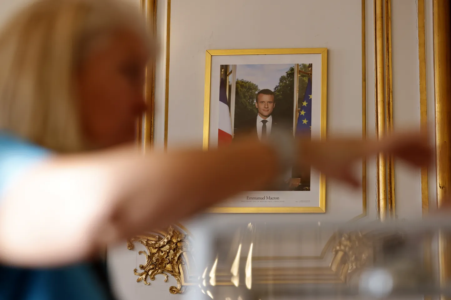 Inimene valimisjaoskonnas, taga foto Emmanuel Macronist.