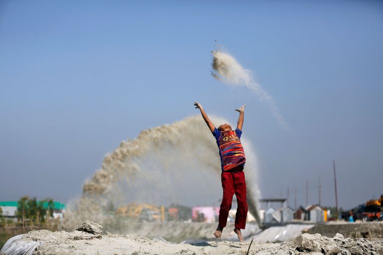 Bangladesh. Poisike mängib liivaga sellal, kui tema ema on tööl. 