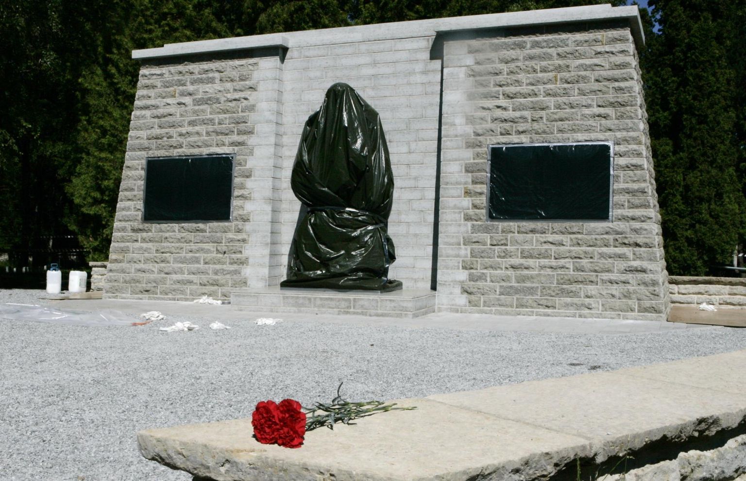 Рядом с Бронзовым солдатом, перенесенным на военное кладбище, построена новая стена, но сам монумент еще обмотан пленкой.