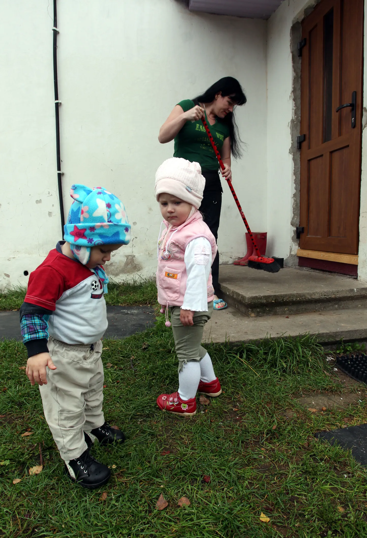 Tudulinnas elav Siivi oma maja ees koos lastega, kes ajutiselt saadeti Narva lastekodusse.