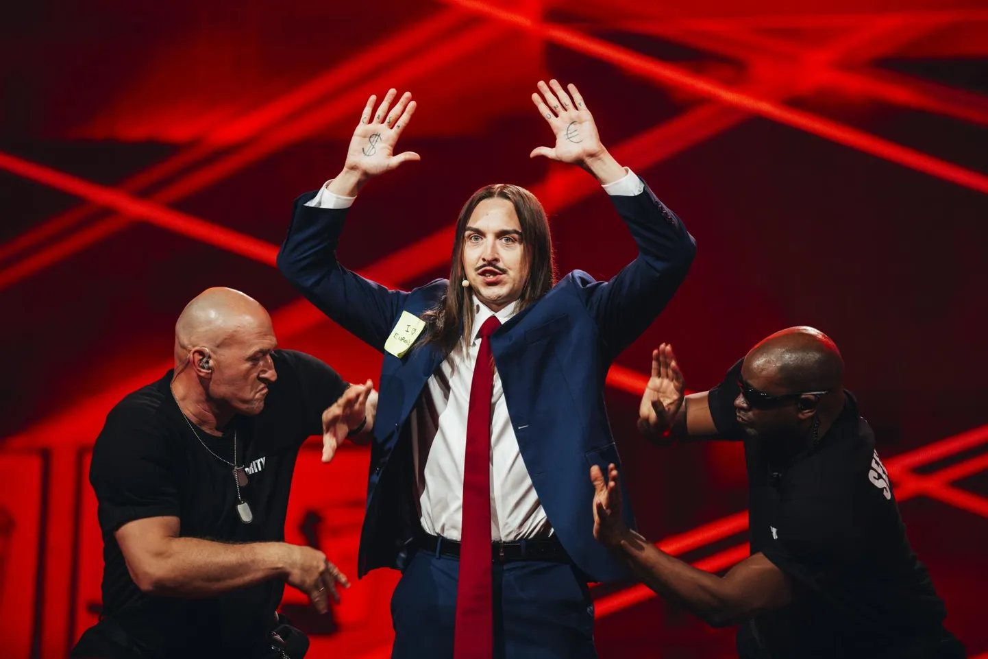 Tommy Cash Eurovisiooni lauluvõistluse poolfinaalis kahe turvamehe vahel.