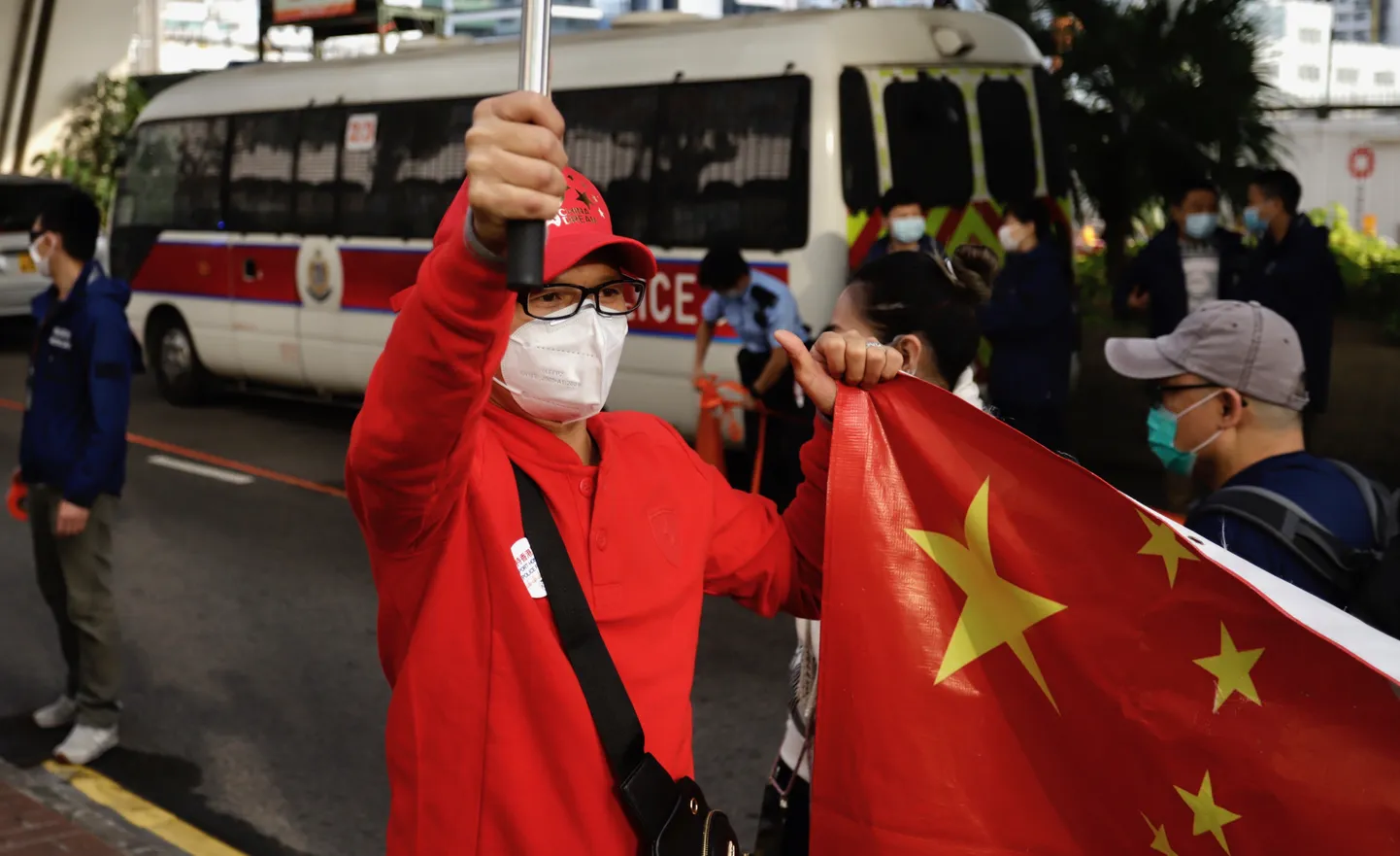Pekingi-meelne aktivist Hiina Rahvavabariigi lipuga demonstreerimas kohtumaja ees, kus peeti istungit 47 demokraatiaaktivisti üle.