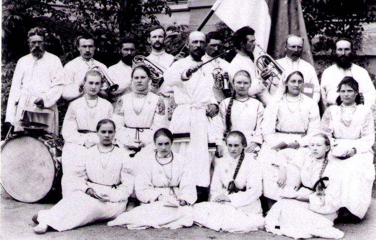 Hansen (keskel dirigendikepiga) poluvernikute rõivastes koos kooriga.
