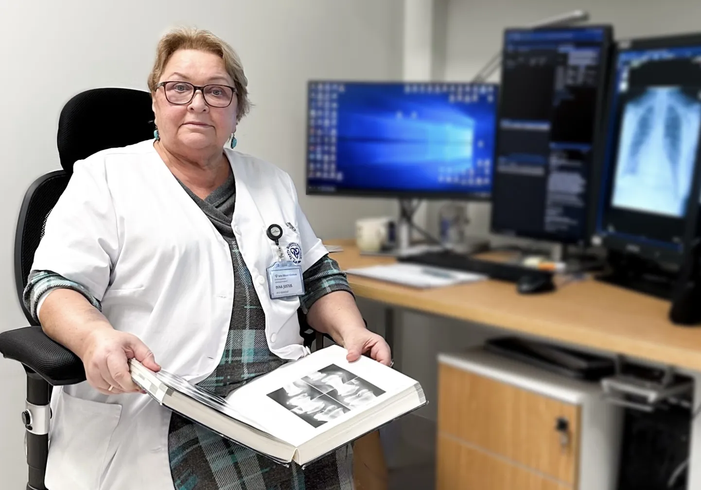 Doktor Inna Justus hoiab süles 800-leheküljelist teost «Atlas of Normal Roentgen Variants That May Simulate Disease», kust radioloog saab pildi tõlgendamisel abi otsida.