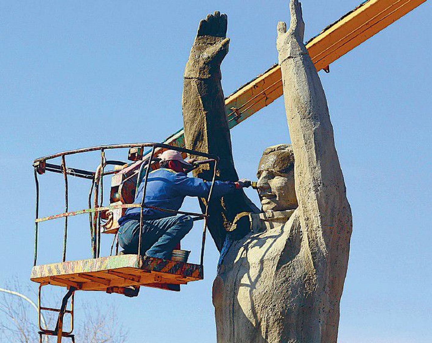 Муниципальный служащий обновляет памятник Юрию Гагарину на космодроме Байконур в Казахстане.