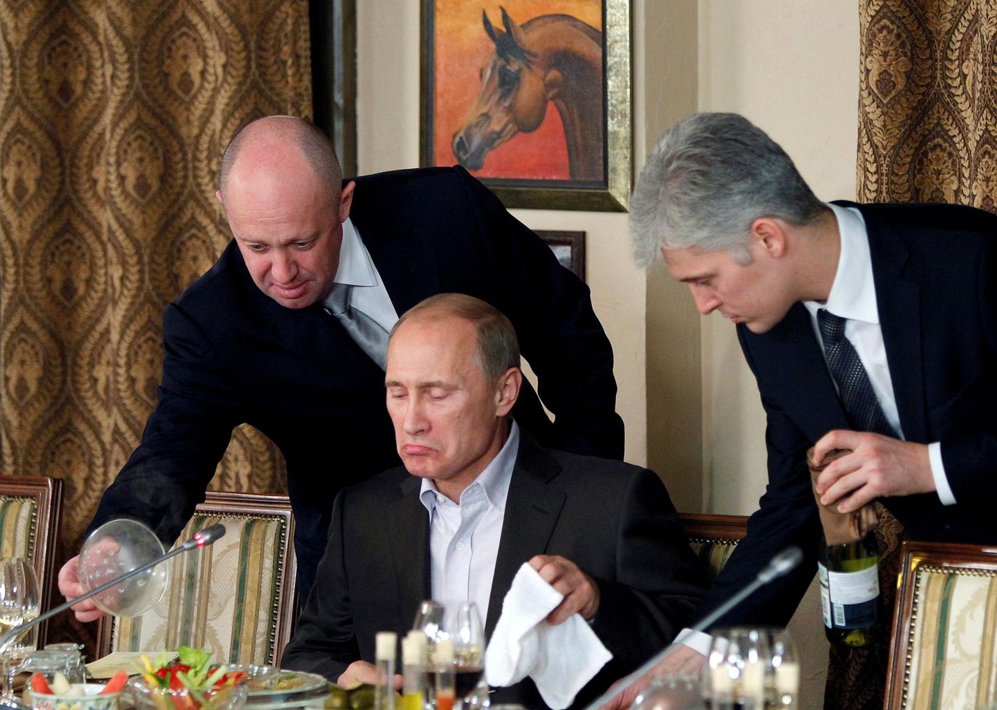Владимир Путин с недоверием смотрит на блюдо, которое ему подает вгений Пригожин в своем ресотране, Санкт-Петербург, Россия, 2010 год.