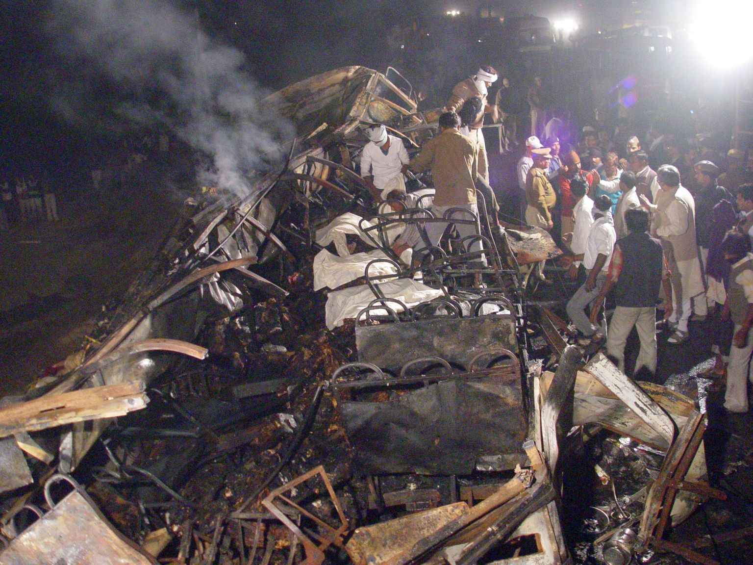 India päästetöötajad ja vabatahtlikud Ferozabadis põlema lahvatanud bussi rusudest ohvrite surnukehasid otsimas.