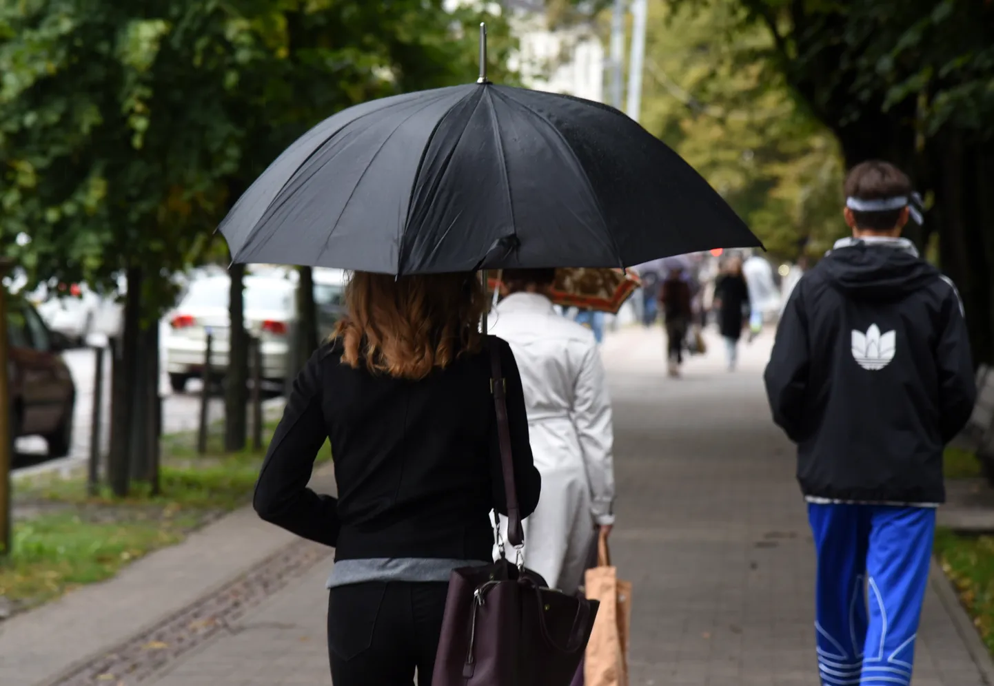 Люди дождливым днем в Риге. Иллюстративное фото