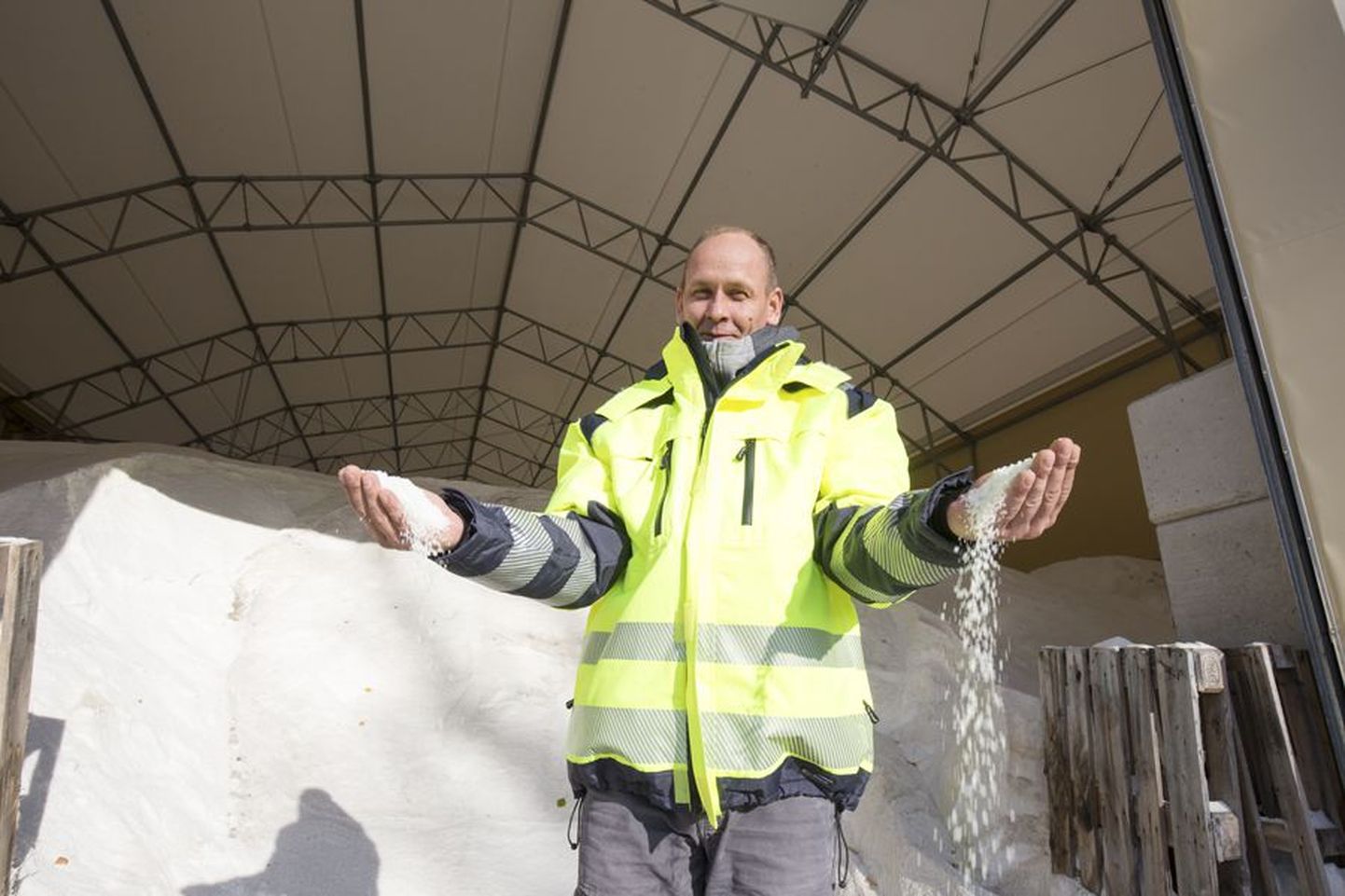 Eesti Keskkonnateenuste Lääne regiooni uues laohoones ootab hooaega 3200 tonni soola. Esiplaanil tänavahooldusmeister Janno Laht.