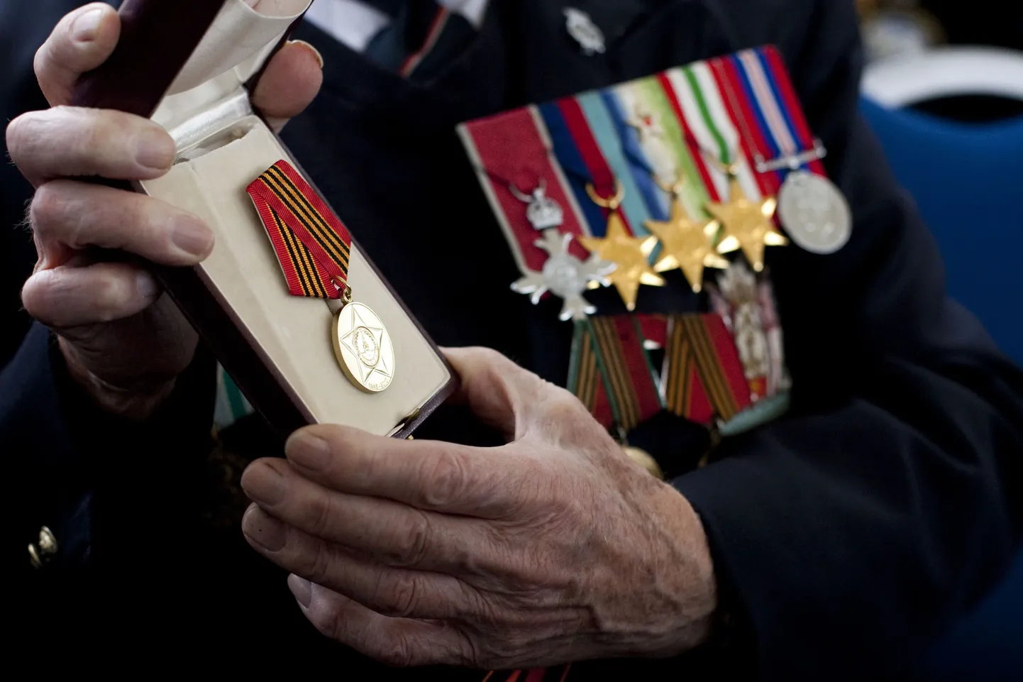 Briti mereväe koosseisus Teises maailmasõjas osalenud veteran demonstreerib Arktika konvoides osalenute mälestusmedalit. Foto on illustratiivne.