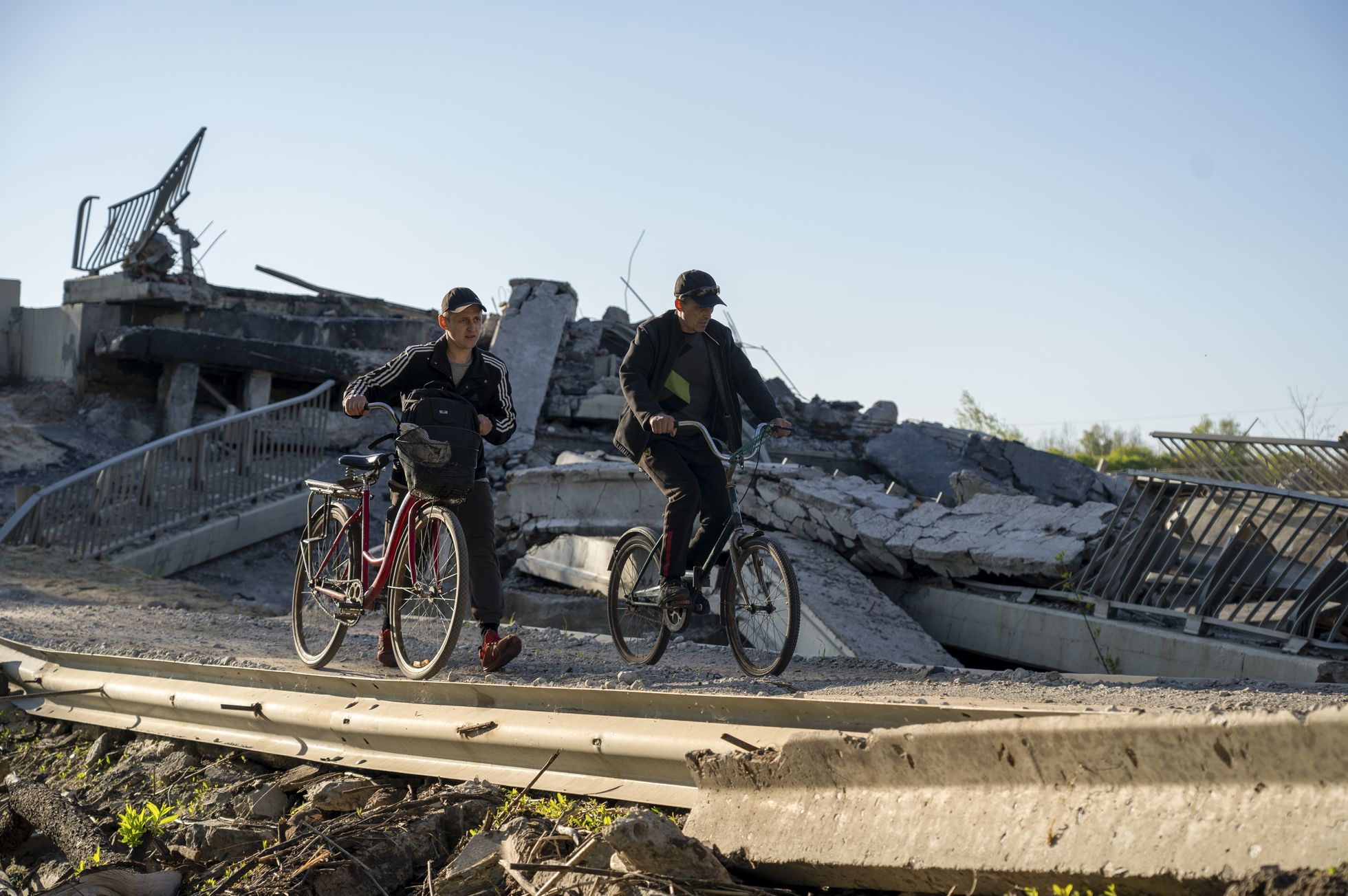 Kohalikud elanikud ületavad jalgratastel purustatud silda Harkivi oblastis Tšuhujivis.