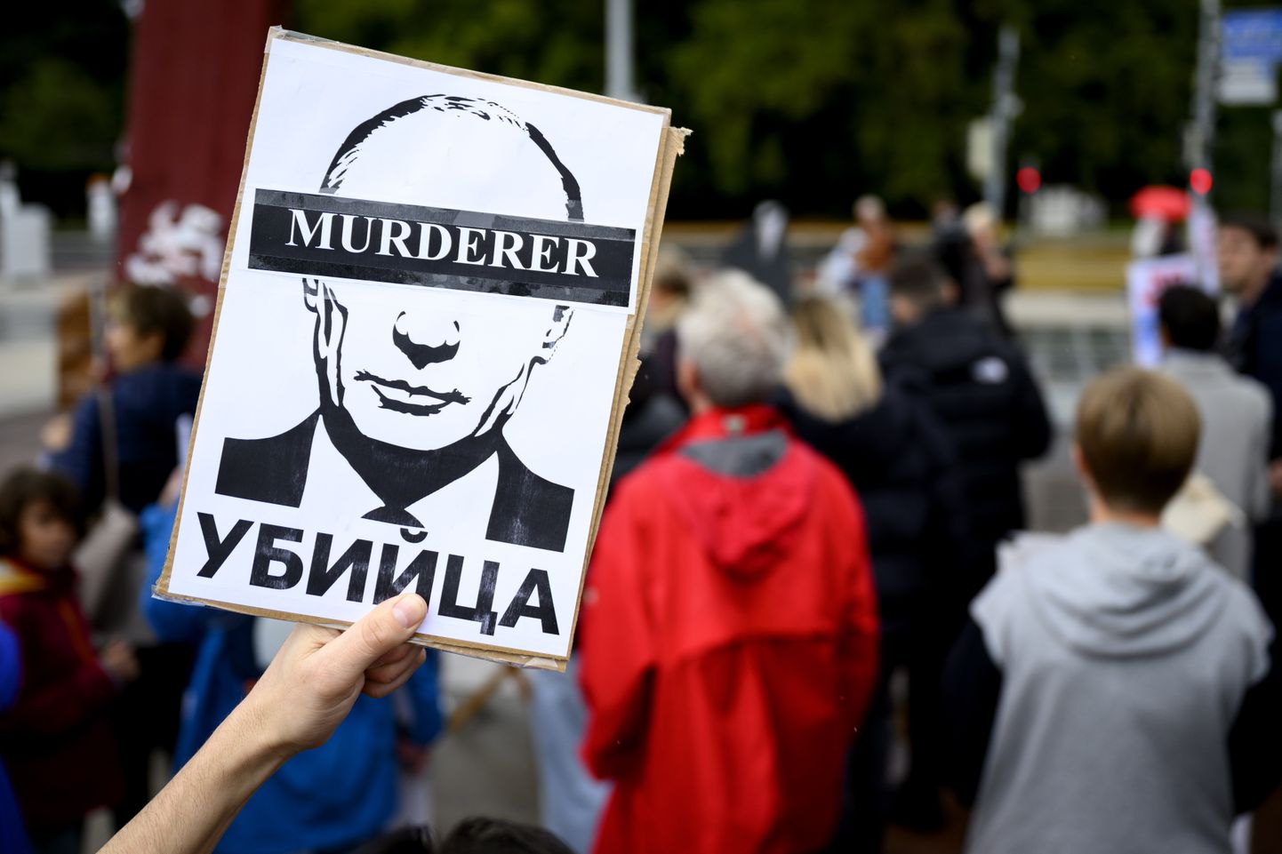 Meeleavaldaja Genfis Putinit mõrtsukaks nimetava plakatiga.