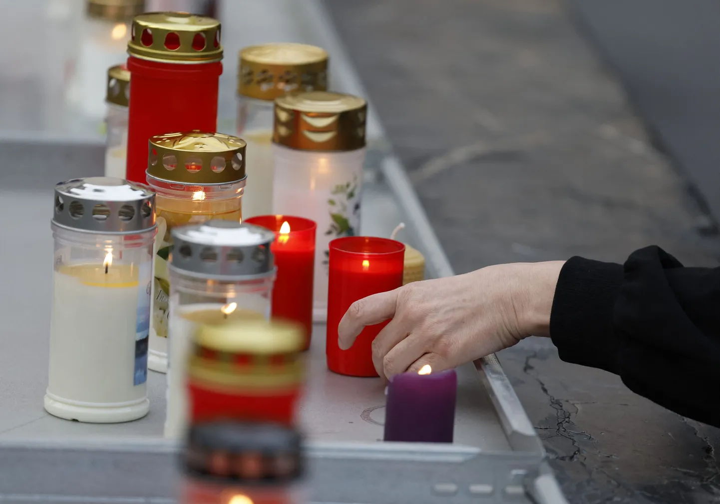 Люди зажигают свечи у стихийного мемориала после гибели нескольких человек в результате стрельбы в школе, 10 июня 2025 года, в городе Грац на юго-востоке Австрии.