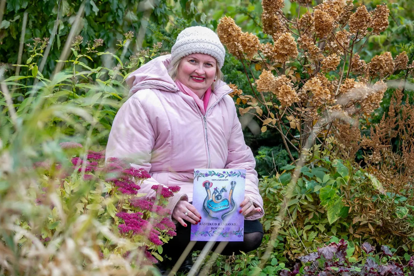 Lastekirjanik Tiina Kilkson veedab poole aastast Tammistes suvekodus. Pildil hoiab ta käes oma värskeimat raamatut.