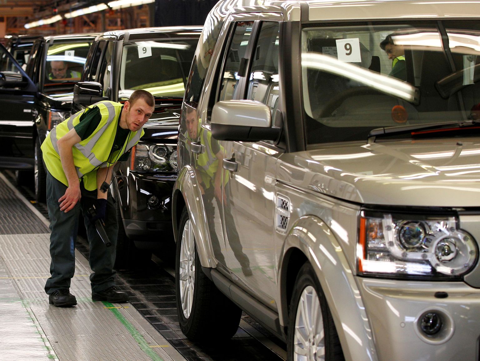 Darbinieks pārbauda Land Rover Discovery automobili ražotnē Solihallā, Lielbritānijā