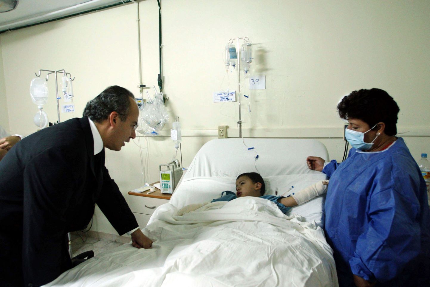 Mehhiko president Felipe Calderon räägib haiglas ühe põlengus vigastada saanud väikese lapsega.