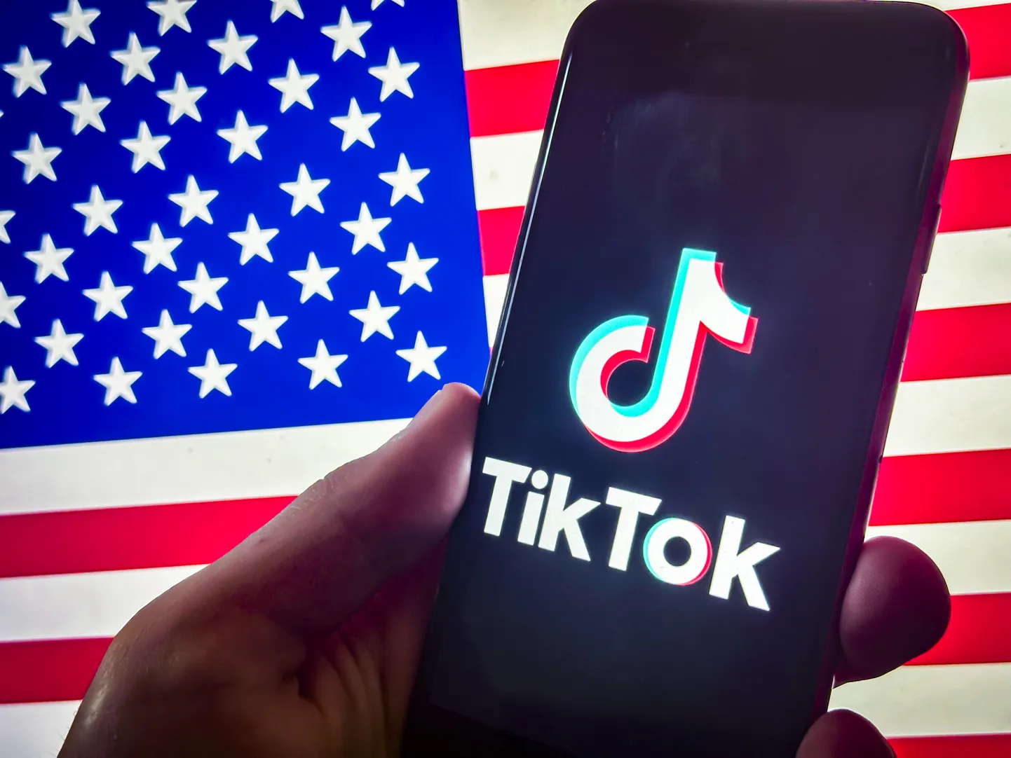 Sotsiaalmeediaplatvormi TikTok logo USA lipu taustal.
