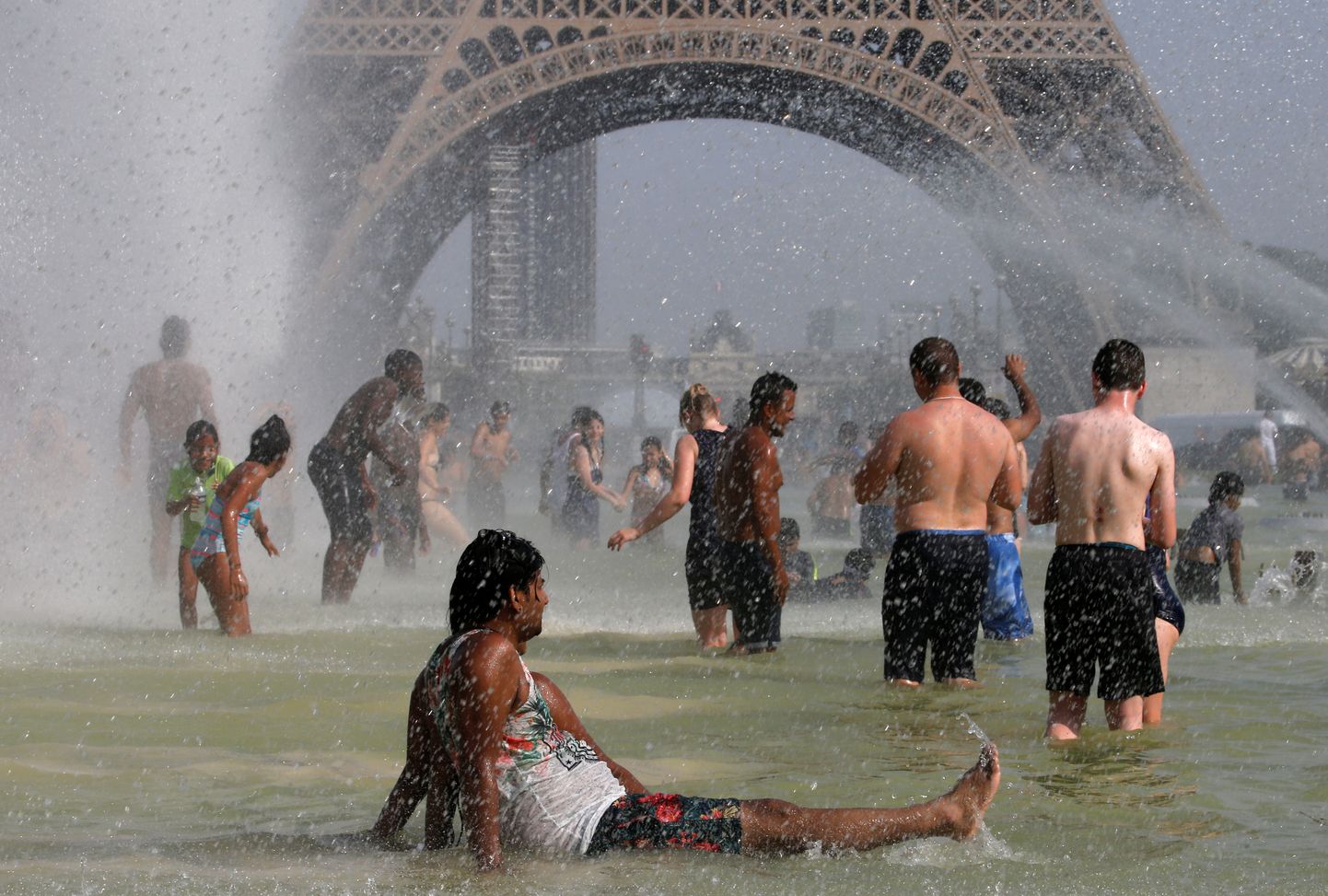 Inimesed Eiffeli torni lähedal purskkaevus kuumaleevendust otsimas.